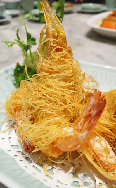 先用蝦籽和蝦肉打成蝦膠然後釀到蝦隻上, 再用一大堆龍鬚絲卷在蝦隻上, 用油炸至金黃, 工序頗為繁複