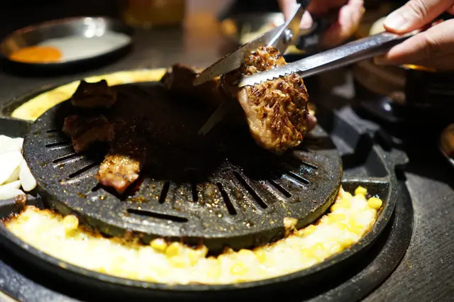 侍應先把五花肉切開,平鋪在燒版之上,待些時候才反到另一面。