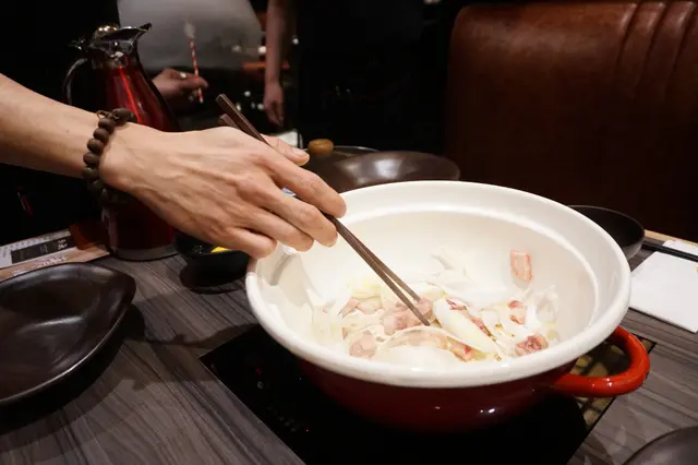 侍應先用牛脂起鍋，並加入香炒洋蔥，再倒入壽喜燒湯汁