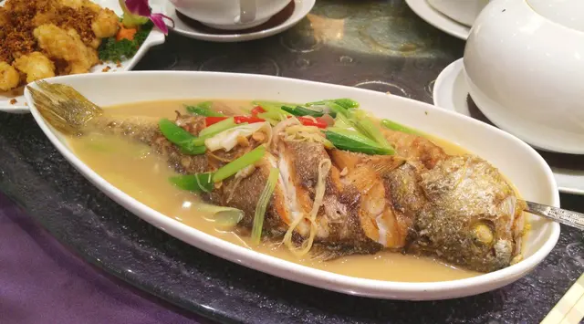 黃花魚半煎香後, 加入蒜、薑、芹菜和辣椒等材料放湯煮熟