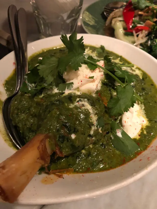 "Lamb Saag" slow-cooked lamb shank simmered in spinach garm masala and tomato served with torn burrata
