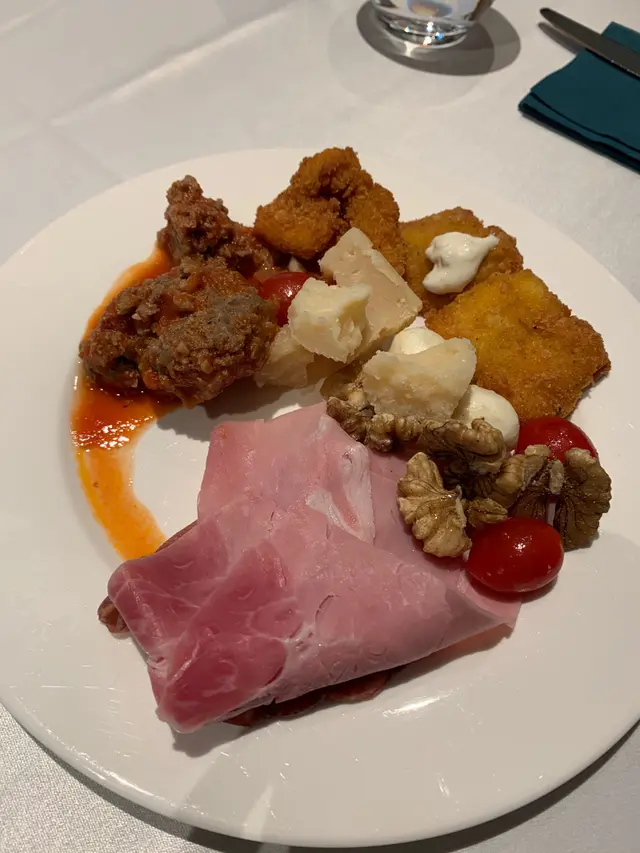 Cold meats, meatballs, parmesan cheese, some walnuts, fried fish and a tomato salad