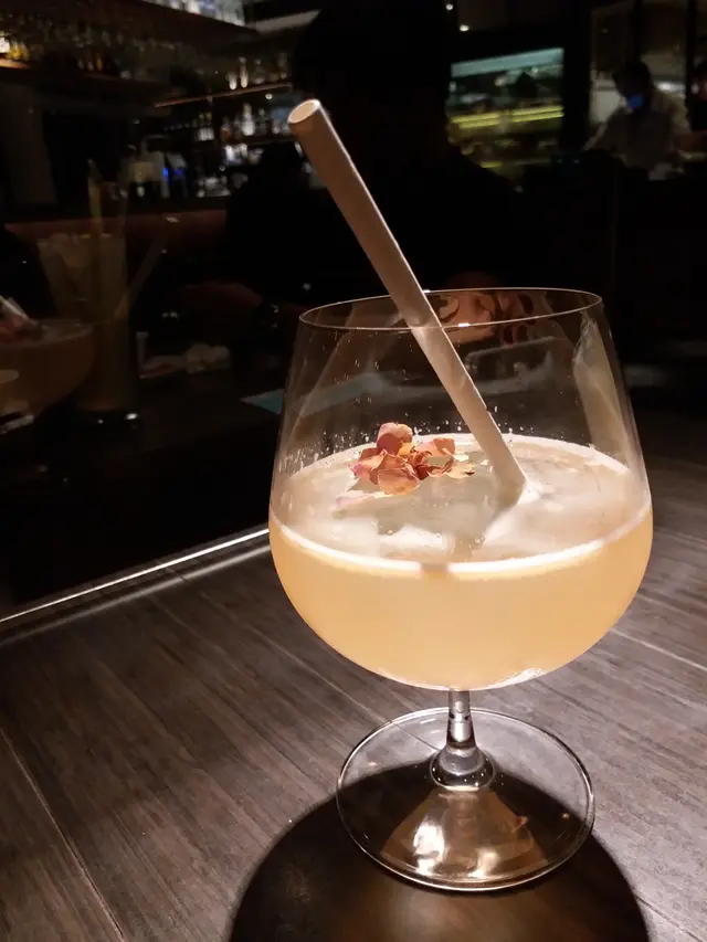 成份：Rose, Lychee, Plum Vinegar, Lime, Tonic
這杯飲品賣上精緻，中間有一夥很大塊不易溶晶瑩剔透的方形冰塊，令這飲品能張時間除了美觀外，更能長時間保存冰凍的溫度，冰塊上還灑上玫瑰花瓣，加上粉色的飲品，賣相很浪漫似的。至於味道呢！還未喝下時，已感受到那芬香撲鼻的玫瑰香，當中帶有一些荔枝的香甜及檸檬的清新，味道層次豐富，真的是很特別的一個飲品呢！