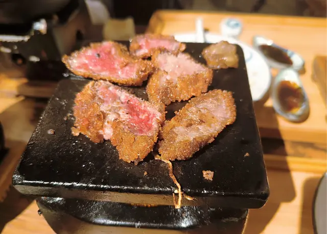 石板上有粒牛脂.鐵板受熱把肥脂肪釋出肥牛油再把吉列牛底面香煎.厚薄均勻.香脆吉列牛外皮香脆.進口咀嚼.牛肉內有少少汁液及牛脂散發甘香!👍😋😋😋