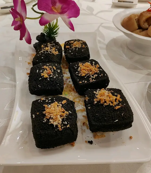 一𥖁𥖁表面黑色的豆腐，面頭鋪上小小炸蒜，令我十分好奇，到底係咩玩法，點知咬一口就感受到外脆內軟，濃郁既豆香從口中爆發，回味無窮。
