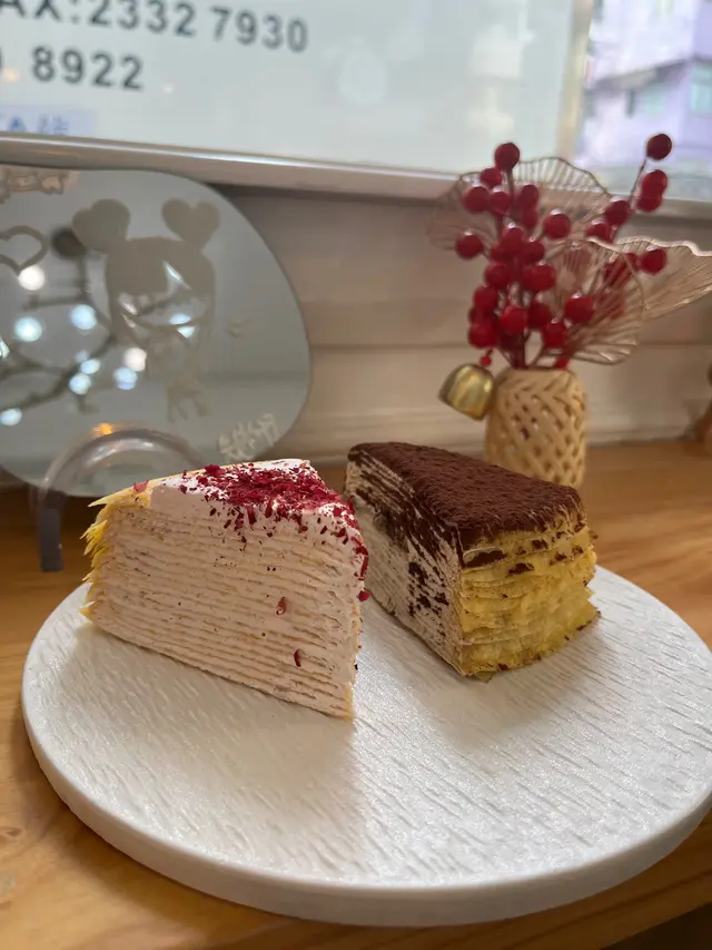 ✨日本牛乳玫瑰千層蛋糕🍰✨
價錢:$42
推薦度:7/10
-
呢款玫瑰千層蛋糕賣相好靚 有啲花瓣喺蛋糕上面🌸 原來店舖採用咗日本天然玫瑰香油同埋玫瑰醬 食落好香玫瑰味 千層蛋糕口感層次分明 每層煎得細薄 數過真係有20層😂 帶有淡淡嘅蛋香味 口感軟熟 忌廉香滑 牛乳味突出 但忌廉比例多咗少少🤏 令整體口感濕潤咗啲 味道偏甜 未去到好驚喜🥹
🤎
✨Tiramisu千層蛋糕🍰✨
價錢:$42
推薦度:7.5/10
-
我同朋友比較鍾意Tiramisu味 咖啡味好突出 味道唔會太甜 呢款嘅忌廉帶有咖啡香 幼滑微甜 但酒味就唔太明顯 食到中間有一層手指餅 沾滿咗咖啡液 食得出好香濃嘅咖啡味 呢款味道層次分明 值得推薦👍🏻
