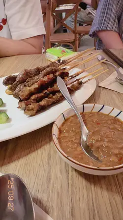烤肉串，啲汁油油亮亮，咬落去仲有啖啖肉香。配啲浓浓嘅酱汁，感觉似花生同香料混埋，微辣又有甜味，配几片黄瓜清清口，超级啱晒！